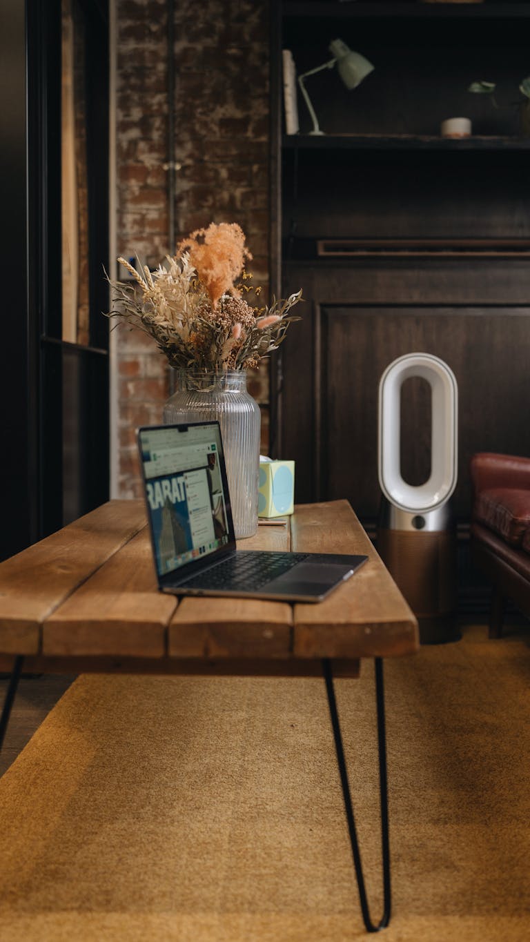 Stylish London loft workspace featuring a laptop, wooden table, and modern decor accents.