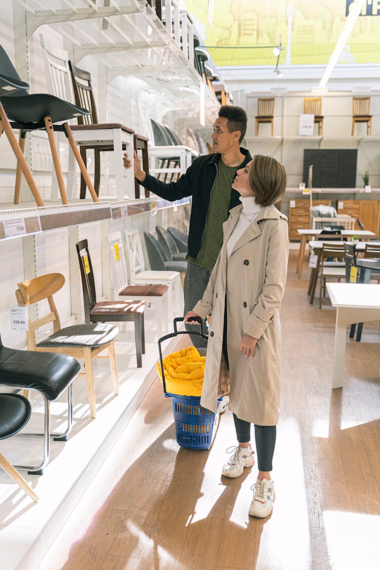 A couple browsing a selection of chairs in a well-lit modern furniture store.
