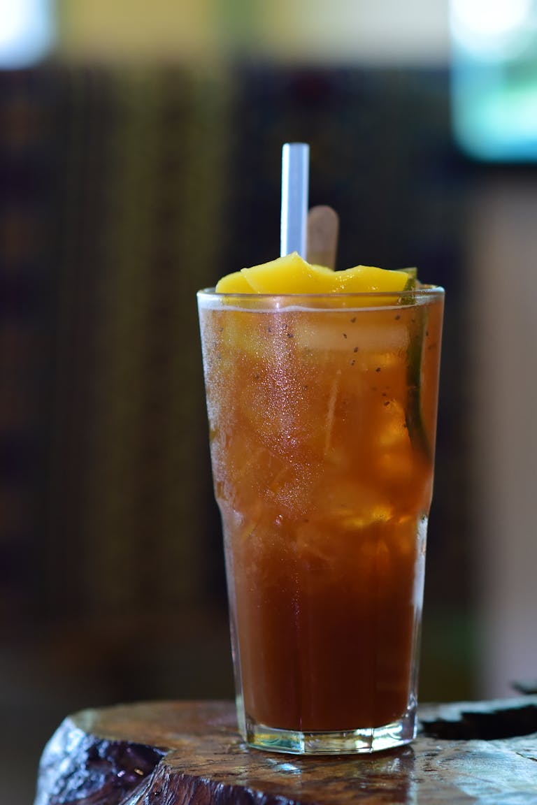 A tall glass of refreshing iced tea with a lemon garnish, ready to enjoy.