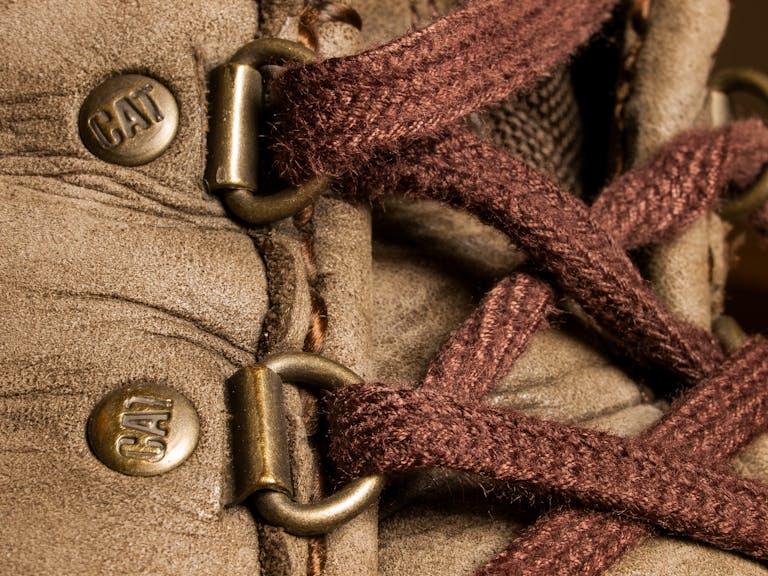 Detailed view of a rugged boot showcasing brown laces and metal eyelets.