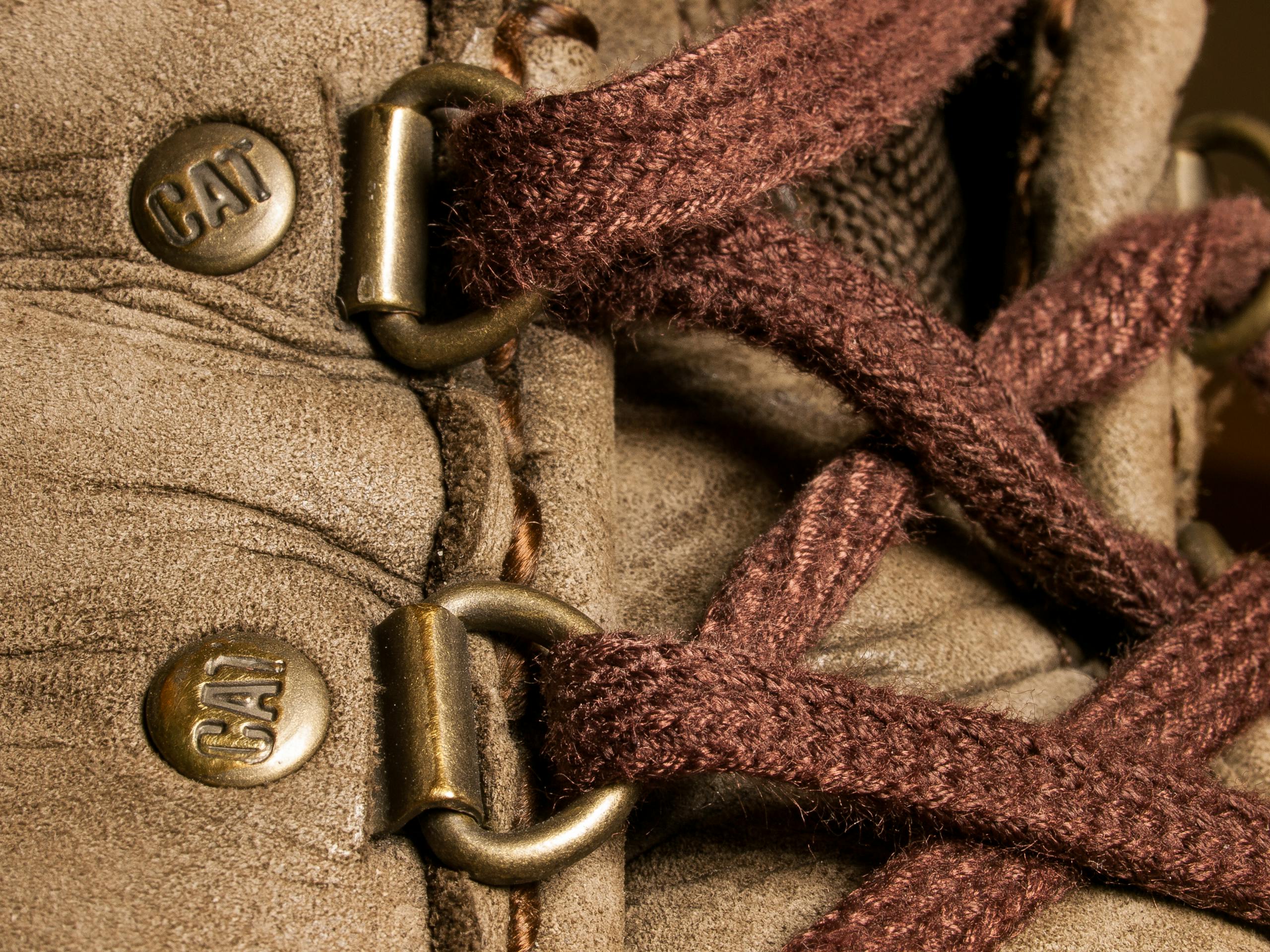 Detailed view of a rugged boot showcasing brown laces and metal eyelets.