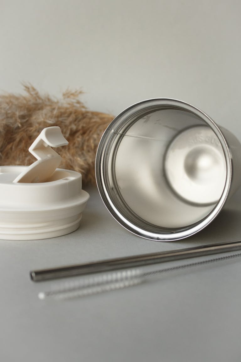 Eco-friendly coffee tumbler with lid and straw in a minimalist setup. Ideal for sustainability themes.