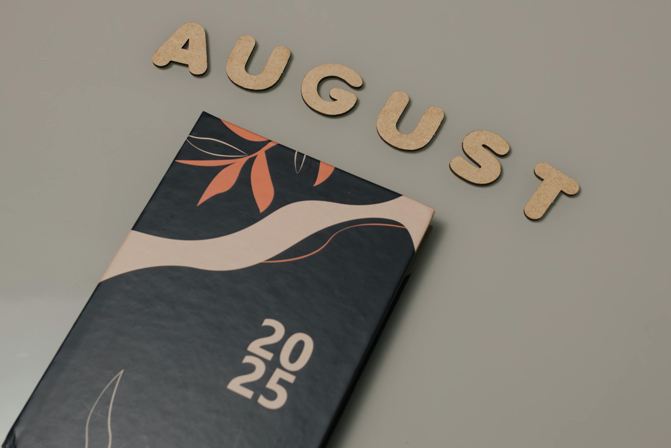 Elegant 2025 planner with decorative cover and August wooden letters.
