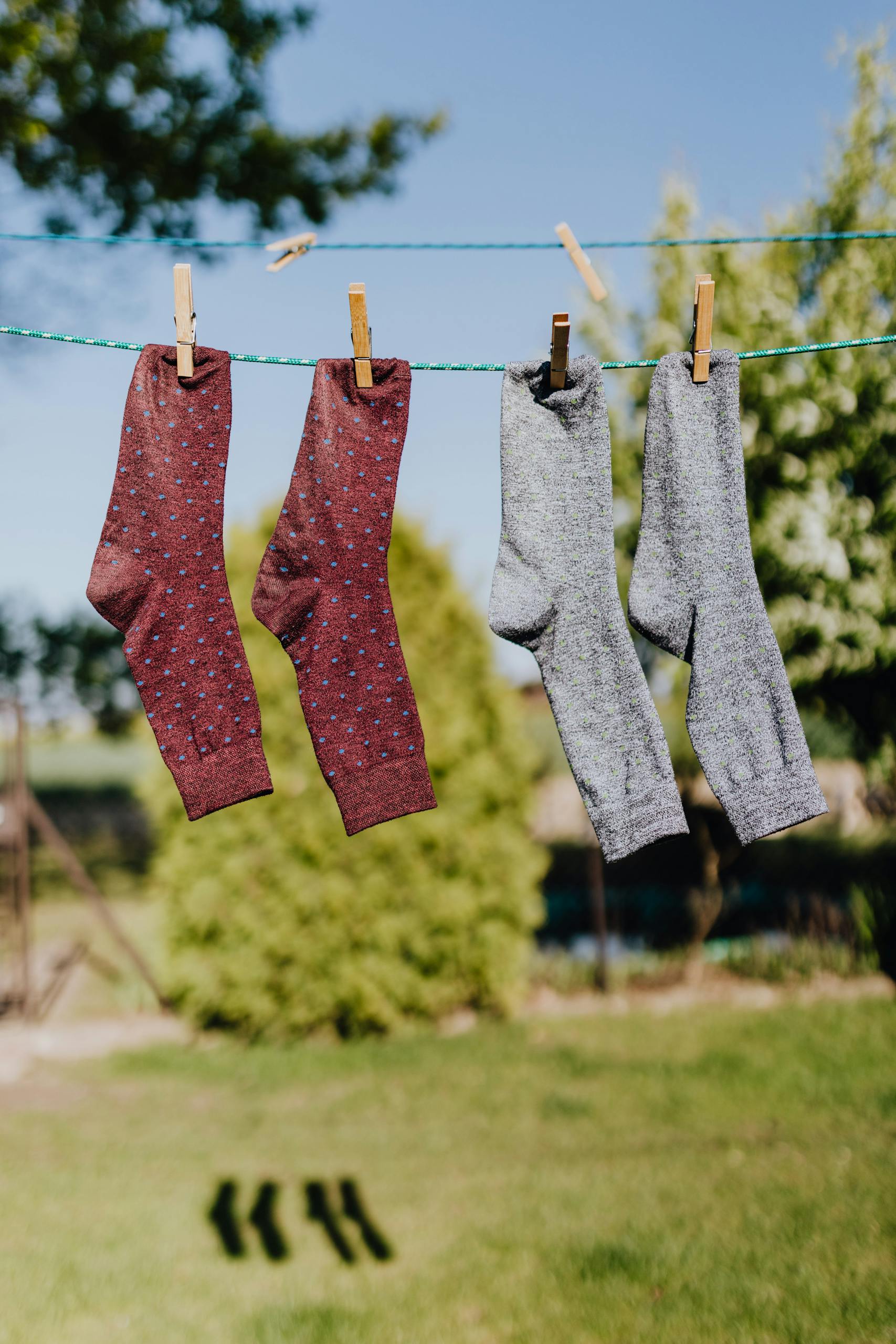 Vibrant socks hanging on a clothesline under a sunny sky, showcasing everyday life and hygiene.