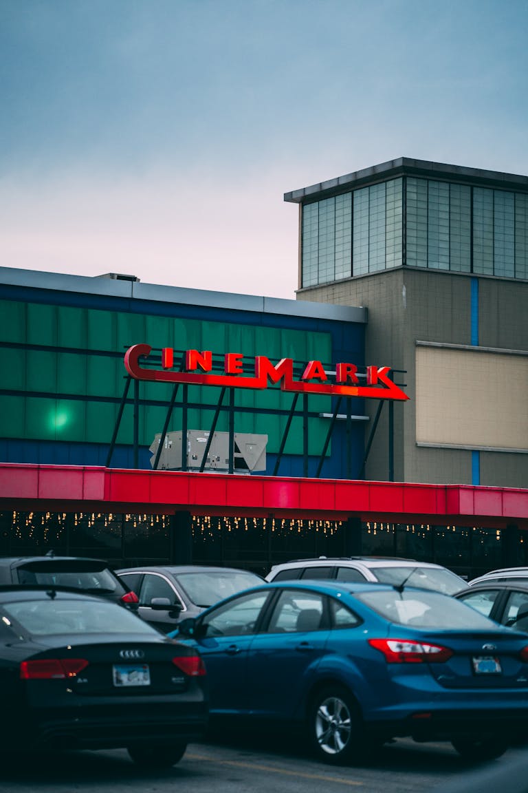 View of Cinemark theater facade with parked cars in Melrose Park, IL.