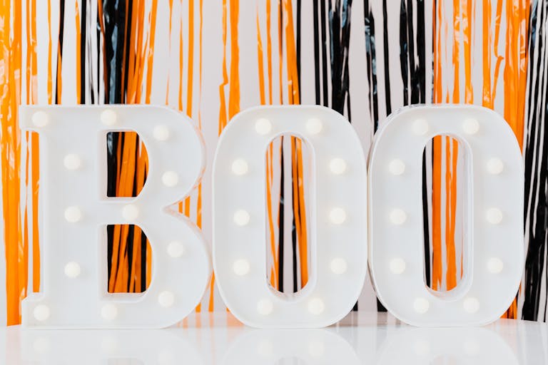 Illuminated 'BOO' sign capturing Halloween spirit with orange and black decorations.