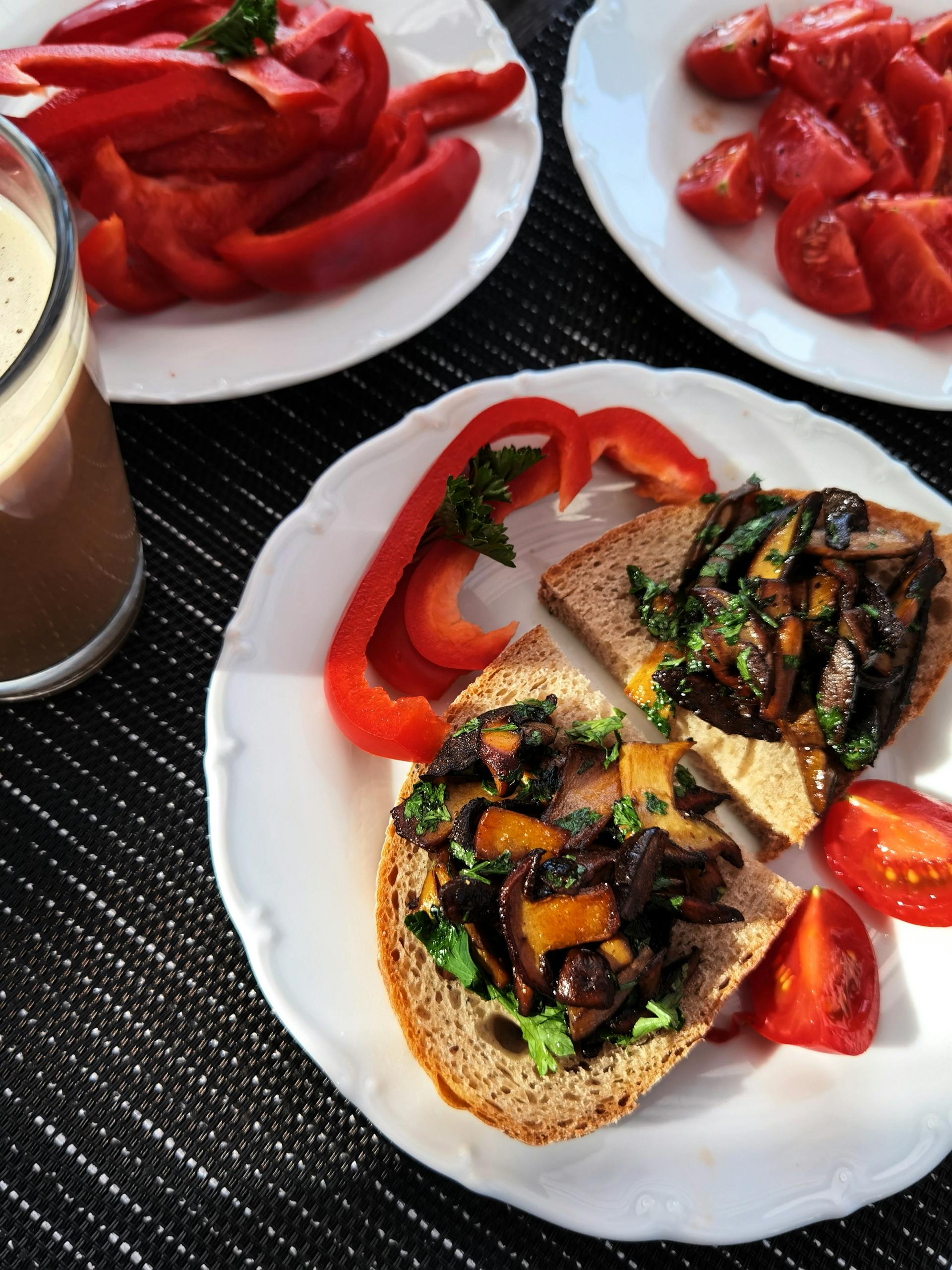 Tasty bruschetta topped with sautéed vegetables served with coffee and fresh tomatoes.