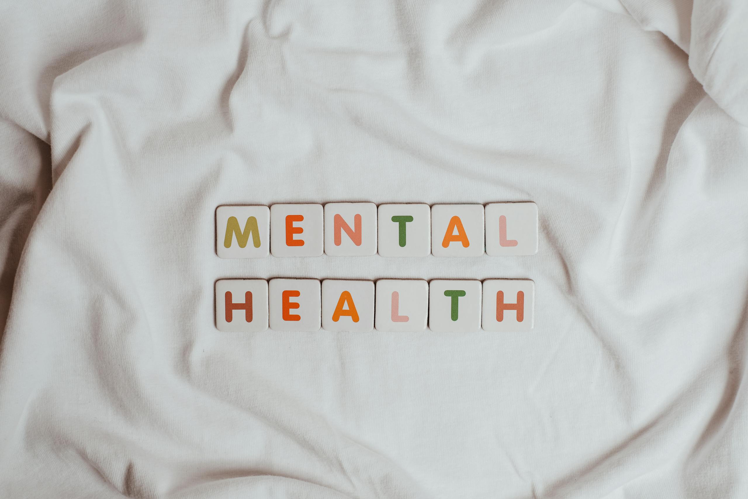 Close-up of 'Mental Health' text on cloth, symbolizing calmness and self-care.