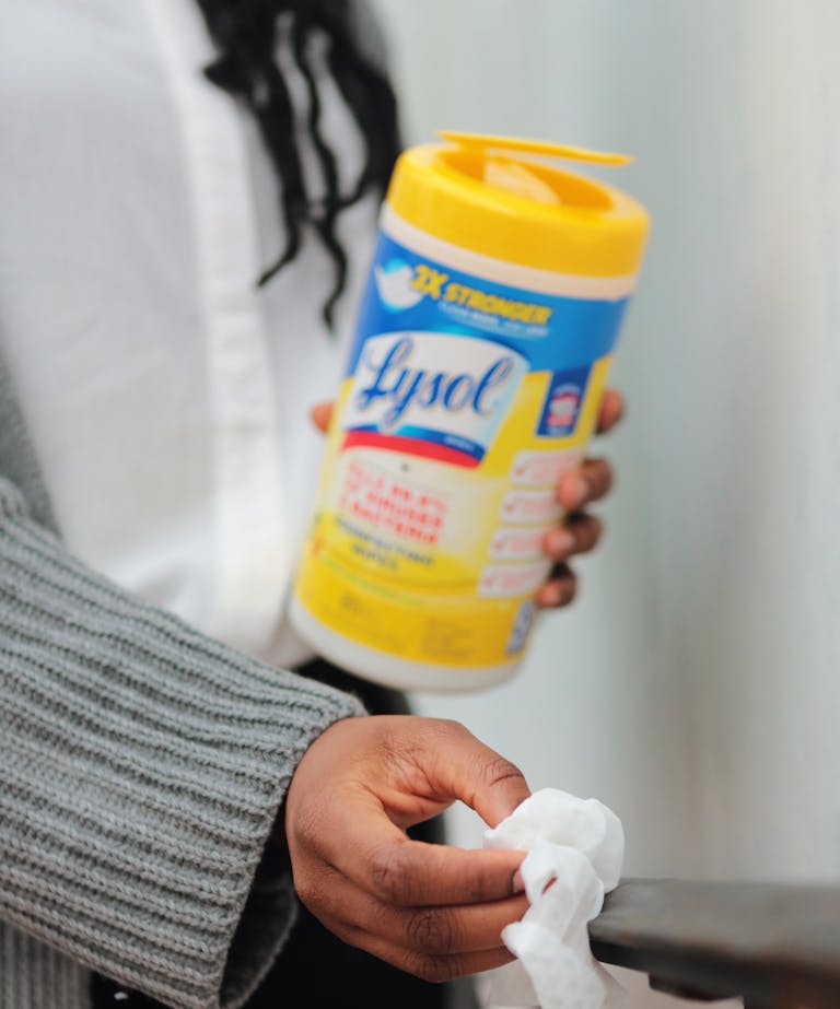 Close-up of a hand holding disinfecting wipes for surface cleaning.