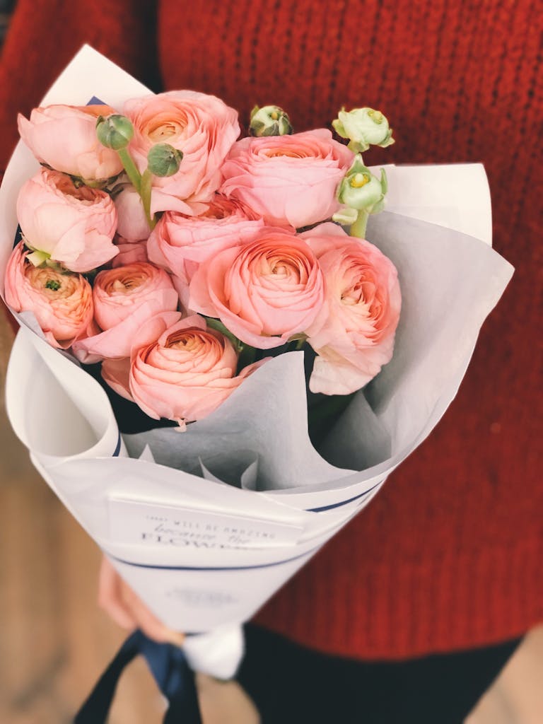 Charming bouquet of pink roses held by a person, perfect for romantic occasions.