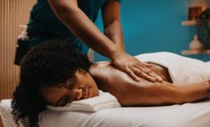 Massage therapist giving a back massage at Hand and Stone