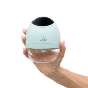 Zomee Fit wearable breast pump held in one hand