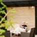 Blonde woman relaxing on modern wooden patio using a smartphone.