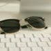 Close-up of stylish sunglasses on a desk with a keyboard, ideal for business and fashion themes.