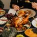 A festive Thanksgiving dinner spread featuring a golden roasted turkey, vegetables, and wine, perfect for holiday dining.