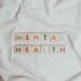 Close-up of 'Mental Health' text on cloth, symbolizing calmness and self-care.