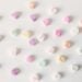 Top view composition of multicolored small heart shaped sweets placed on plain white surface