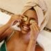 Woman enjoying a spa bath with cucumber slices on eyes, embracing relaxation.