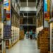 A vibrant warehouse aisle with shoppers amidst towering shelves in Brazil.